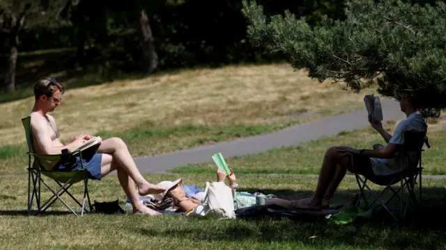 People read books in the sunshine in Greenwich Park as record temperatures are forecast over the weekend, in London, Britain, May 24, 2026.