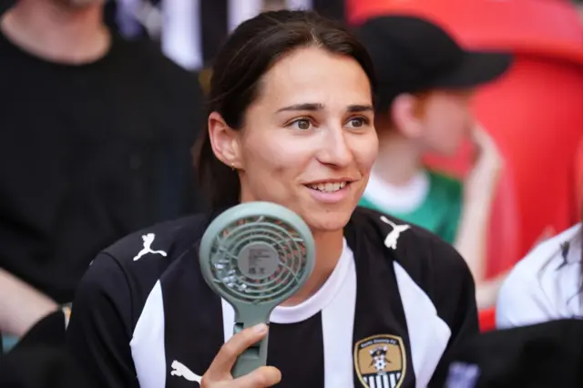 A female Notts County supporter holds a fan at Wembley