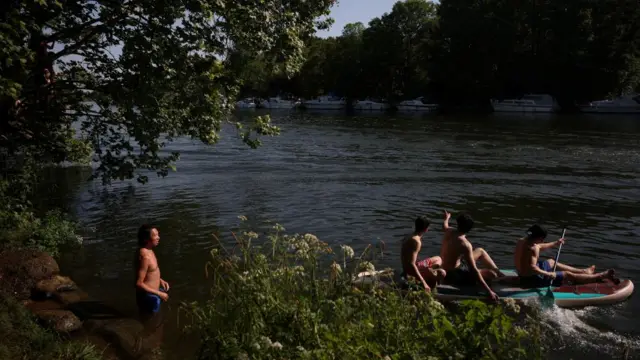 People bathe in the River Thames at Teddington Lock on Sunday.