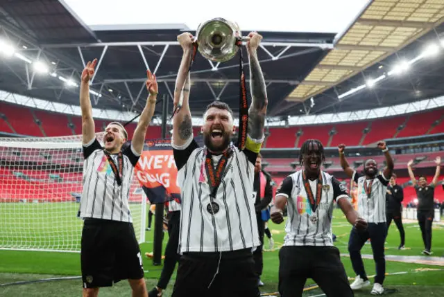 Kyle Cameron lifting the National League play-off trophy in 2023