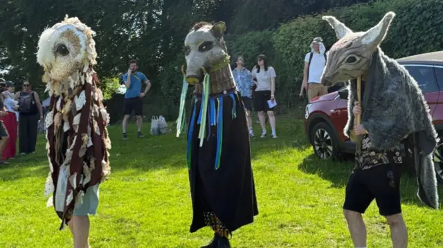 People dressed as animals are standing on the hill.