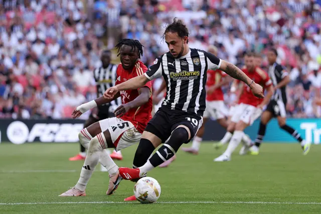Jodi Jones of Notts County controls the ball while under pressure from Rosaire Longelo of Salford City