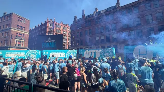 Fans in Stevenson Square with open top buses parked up ready for the parade