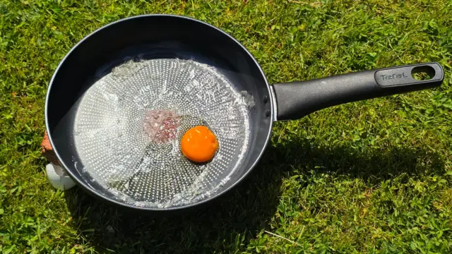 An egg in a frying pan in the sun