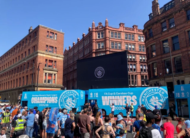 Manchester City fans gather in Stevenson Square as the buses arrive ahead of the parade