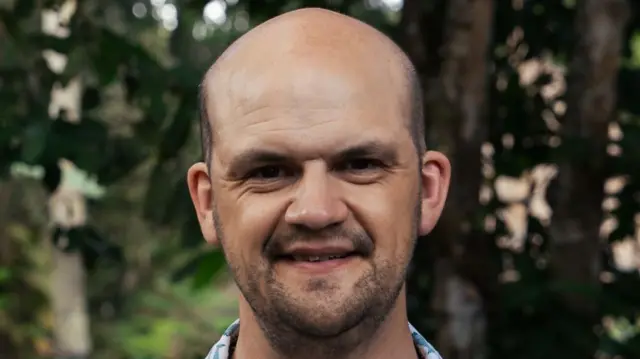 A head and shoulders photograph of Edd Moore, pictured outside.