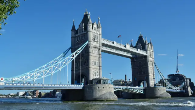 Tower Bridge is pictured from the bank of the river Thames on a sunny day