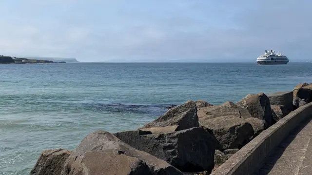 A blue sea alongside a stretch of rocky coast