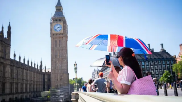 A tourists takes a photo of Big Ben