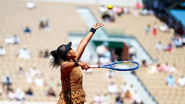 Osaka throwing the ball up for serve