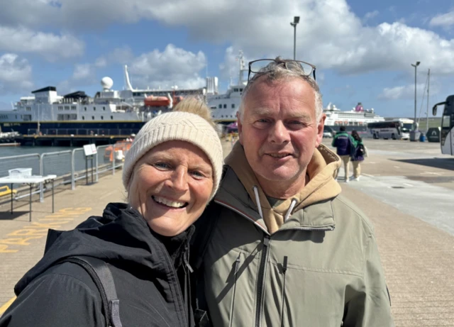 Cruise passengers Claudia and Thierry stand together in Shetland wearing a number of layers despite the sun still shining