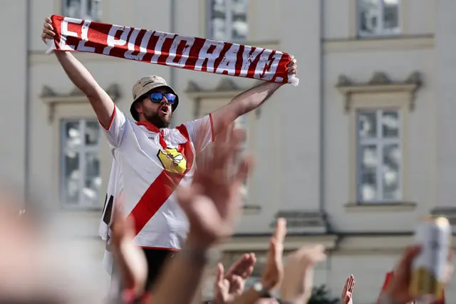 Rayo Vallecano fan holding a club scarf in the air