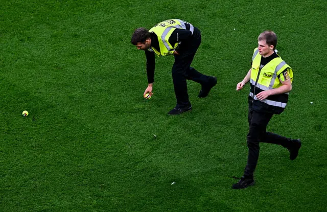 Stewards remove tennis balls