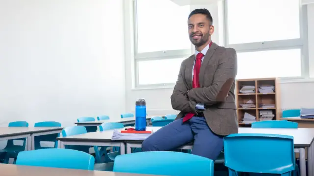 Bobby Seagull in classroom environment wearing suit and tie