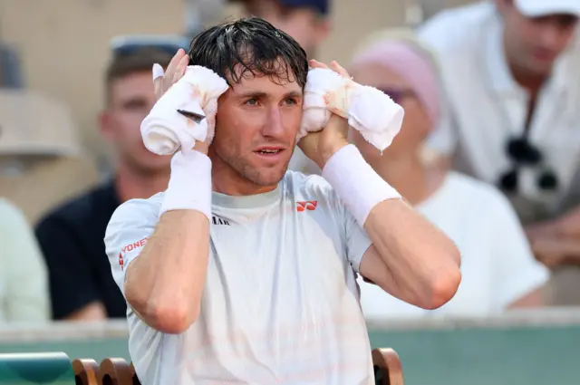 Casper Ruud sits with an ice towel around his head