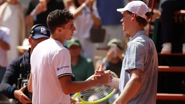 Juan Manuel Cerundolo shakes hands with Jannik Sinner