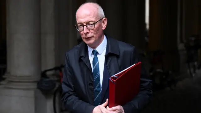 Pat McFadden holds a red folder
