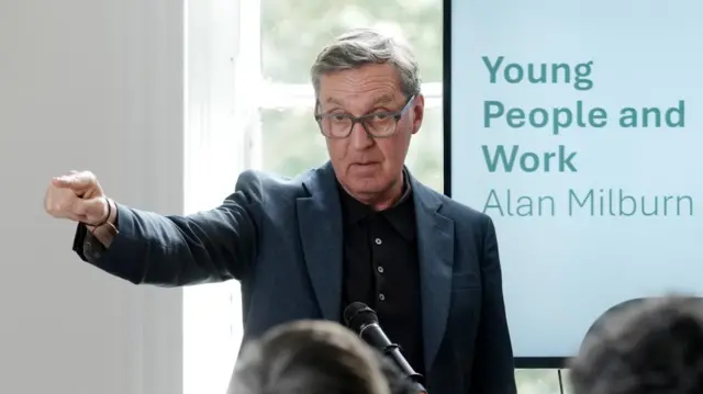 Former heath secretary Alan Milburn points as he delivers a speech following his report looking at young people and work