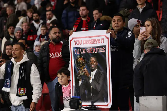 Fans of Paris Saint-Germain's French forward #10 Ousmane Dembele hold up a placard of him