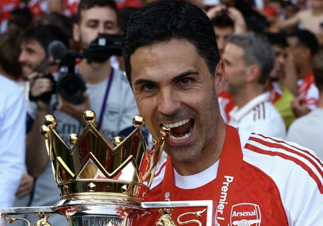 Arsenal manager Mikel Arteta celebrates with the trophy after winning the Premier League