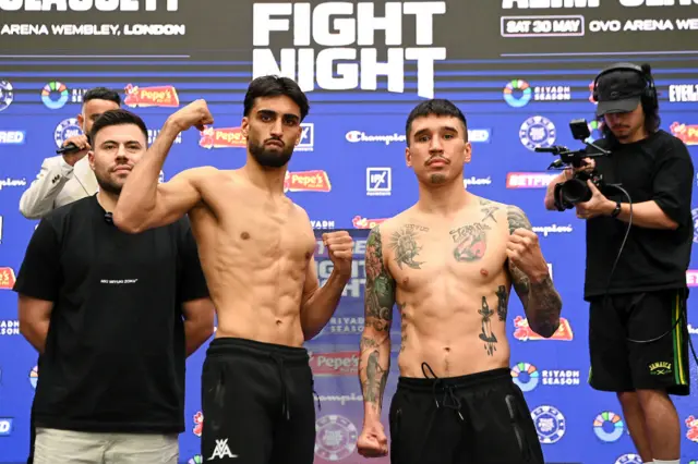 Adam Azim and Steve Claggett are shirtless and holding up their fists