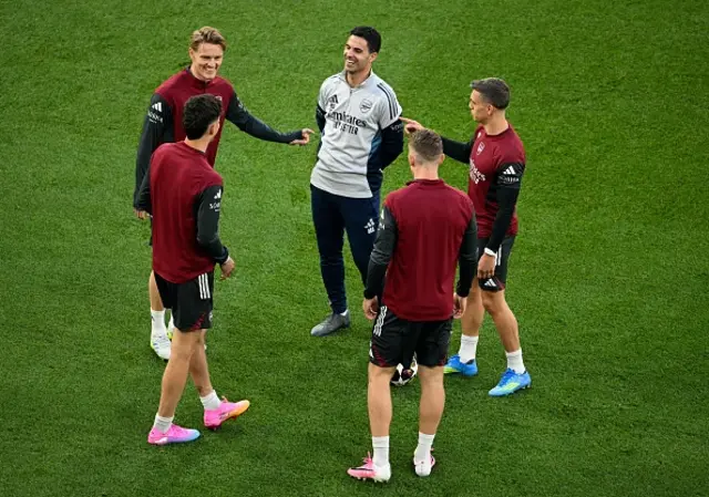 Arsenal's Spanish manager Mikel Arteta (C) speaks with Arsenal's Norwegian midfielder #08 Martin Odegaard