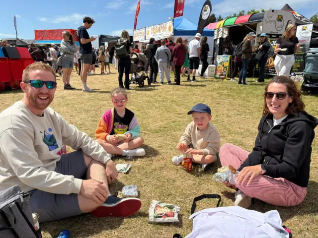 Dau blentyn a dau oedolyn yn bwyta picnic
