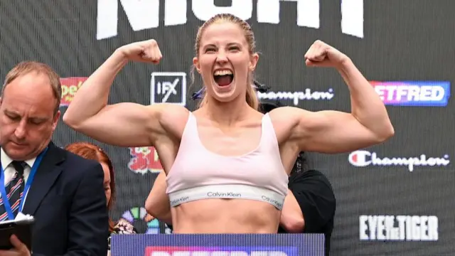 Fran Hennessy holds up her arms as she stands on the scales
