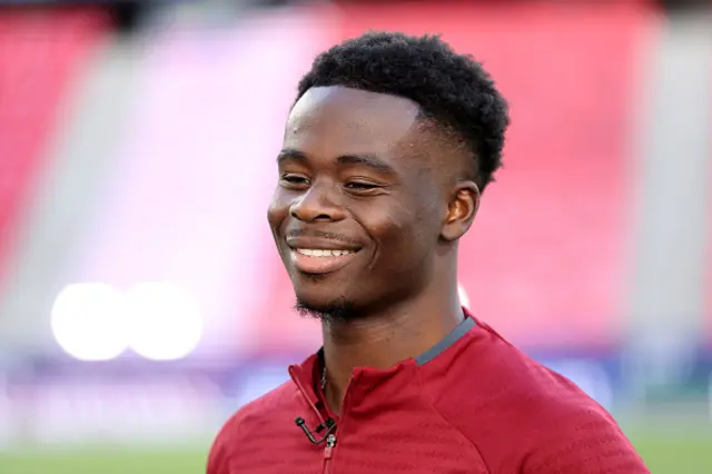 Bukayo Saka of Arsenal is interviewed pitch side