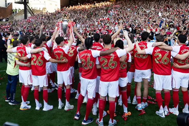 Arsenal players celebrate in front of their supporters