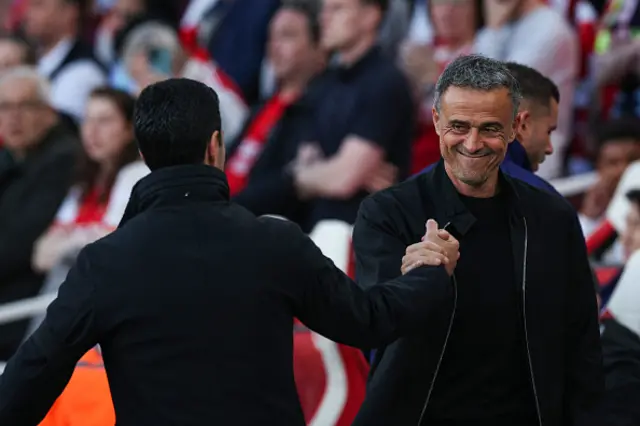 Arsenal's Spanish manager Mikel Arteta (L) and Paris Saint-Germain's Spanish head coach Luis Enrique shake hands