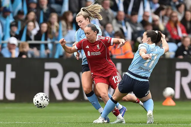 Manchester City's midfielder Sam Coffey challenges Liverpool's Mia Enderby