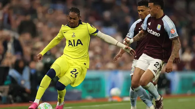 A Spurs player beats the Villa players to the ball