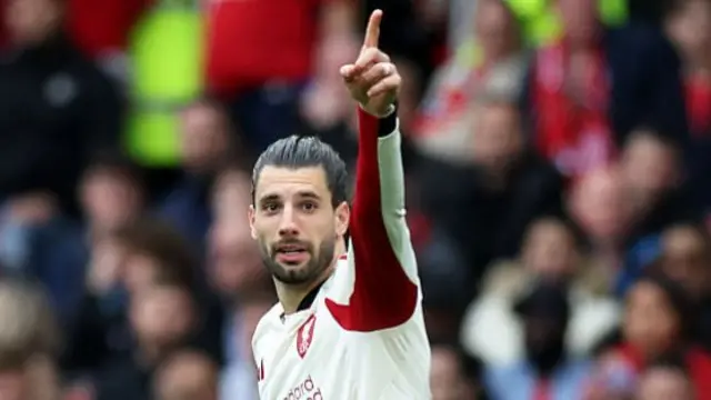 Liverpool's Hungarian midfielder #08 Dominik Szoboszlai celebrates scoring the team's first goal during the English Premier League football match between Manchester United and Liverpool at Old Trafford in Manchester