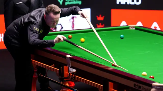 Shaun Murphy plays a shot with the rest