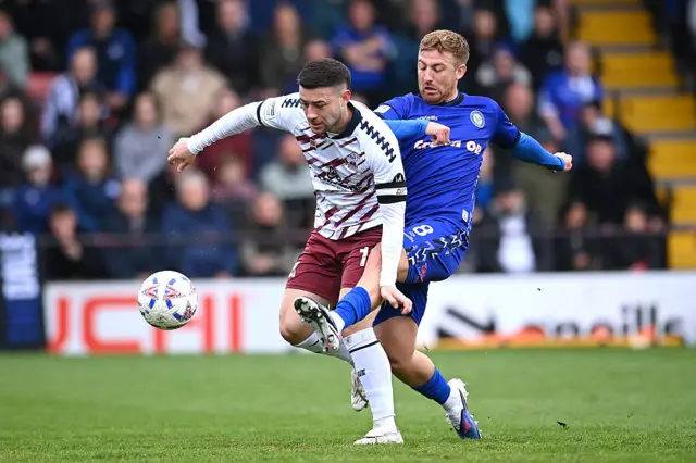 Callum Roberts of Scunthorpe is challenged by Harvey Gilmour of Rochdale