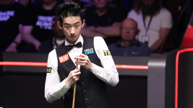 Wu Yize chalks his cue