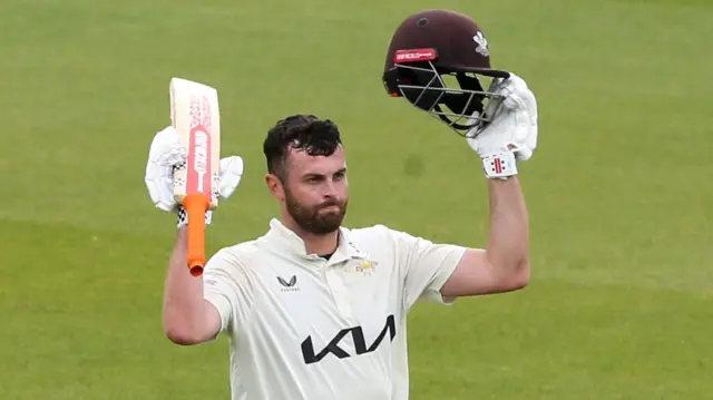 Dom Sibley of Surrey raises bat and helmet