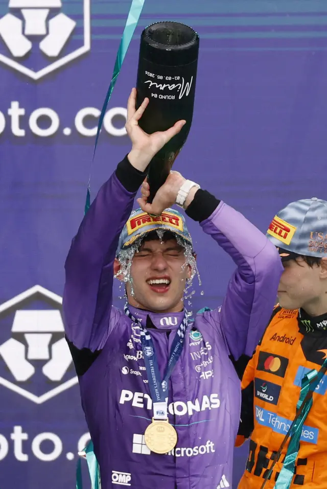 Kimi Antonelli pouring champagne over his head on the podium in Miami