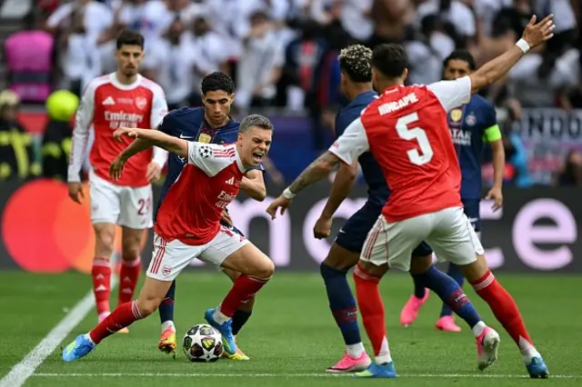 Arsenal's Belgian midfielder Leandro Trossard (C) and Paris Saint-Germain's Moroccan defender Achraf Hakimi vie for the ball