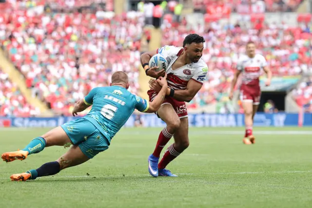 WIgan's Bevan French fends off Hull KR's Mikey Lewis to go on and score a try.