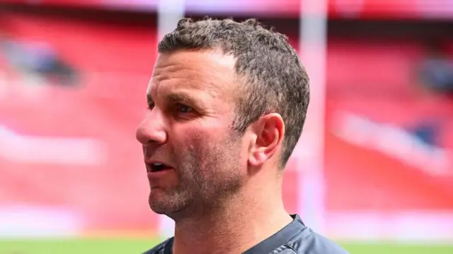 Hull KR coach Willie Peters talking to the media pitchside at Wembley.