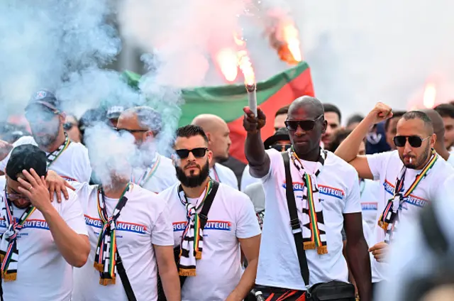 PSG supporters cheer as they march towards the stadium in Budapest