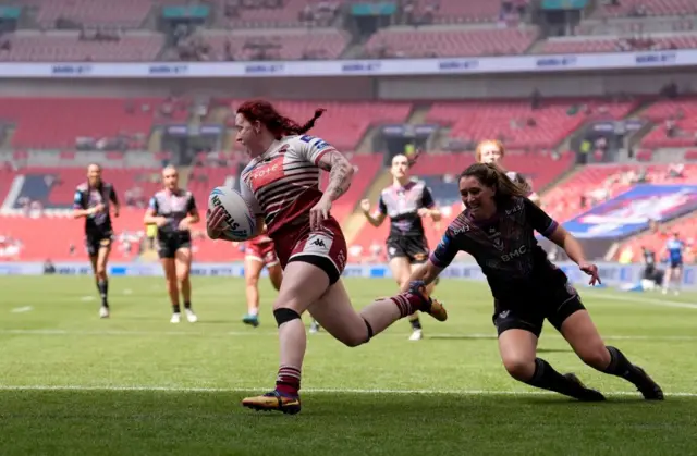 Wigan Warriors' Eva Hunter (left) runs in to score