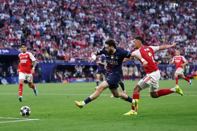 Khvicha Kvaratskhelia of Paris Saint-Germain shoots while under pressure from William Saliba