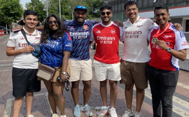 Arsenal fans outside the Emirates smile