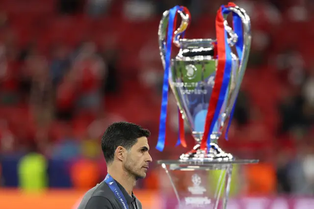 Arsenal's Spanish manager Mikel Arteta walks past the trophy