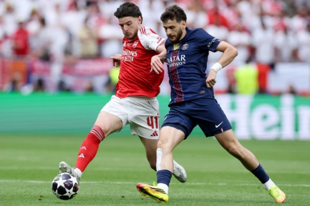 Arsenal's Declan Rice in action with Paris St Germain's Khvicha Kvaratskhelia