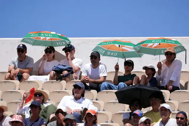 Fans at the French Open shelter from the sun