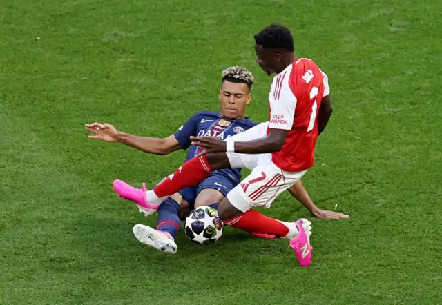 Desire Doue of Paris Saint-Germain is fouled by Bukayo Saka
